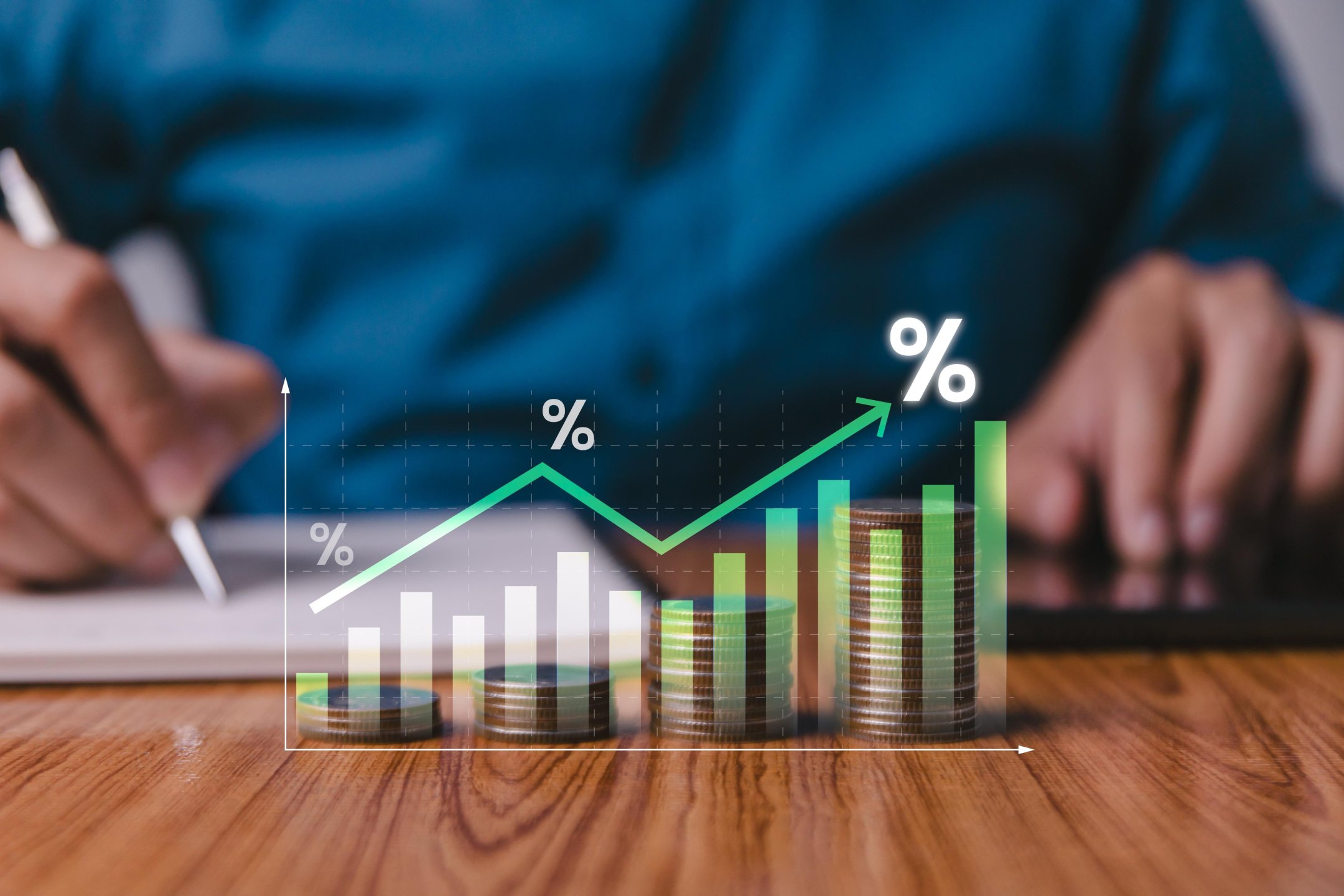 Stacks of coins in front of a rising bar chart with percent signs.